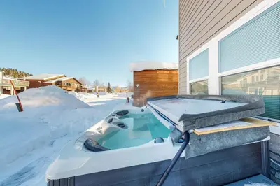 a bath tub sitting outside of a house in the snow at Quail Nest on Quail Drive in Fraser