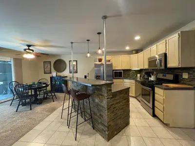 a kitchen with a counter and a table and chairs at Couples Retreat with Hot Tub, Sauna and Steam Room in Fort Collins