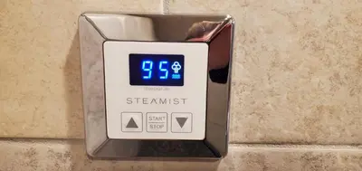 an alarm clock on a wall in a bathroom at Couples Retreat with Hot Tub, Sauna and Steam Room in Fort Collins