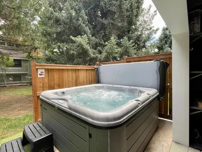 a hot tub sitting on a patio next to a fence at Couples Retreat with Hot Tub, Sauna and Steam Room in Fort Collins