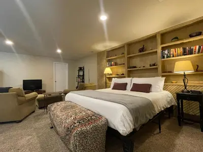 a bedroom with a large bed and a living room at Couples Retreat with Hot Tub, Sauna and Steam Room in Fort Collins