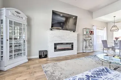 a living room with a fireplace and a tv at Modern-Chic Englewood Home with Yard and Office! in Englewood