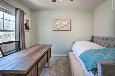 a bedroom with a bed and a wooden table at Modern-Chic Englewood Home with Yard and Office! in Englewood