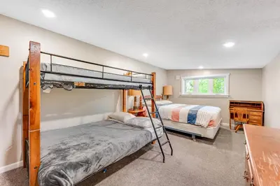 a bedroom with two bunk beds and a desk at Misty Meadow in Fraser