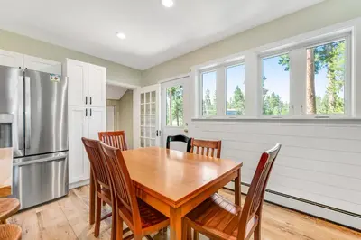 a kitchen with a wooden table and chairs at Misty Meadow in Fraser