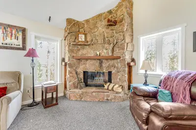 a living room with a large stone fireplace at Misty Meadow in Fraser