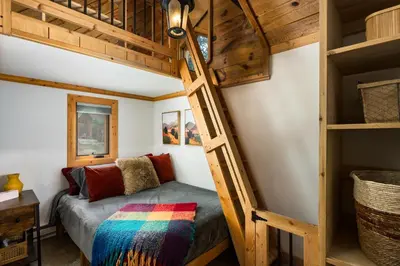 a bunk bed in a tiny room with a ladder at The Evergreen Castle in Evergreen