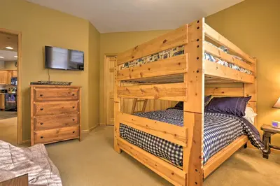 a bedroom with a wooden bunk bed and a tv at Mountainside Grand Lake Condo with Patio! in Grand Lake
