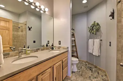 a bathroom with two sinks and a toilet at Mountainside Grand Lake Condo with Patio! in Grand Lake
