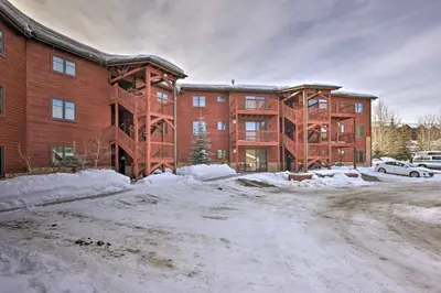 a large brick building with snow in front of it at Mountainside Grand Lake Condo with Patio! in Grand Lake