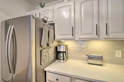 a kitchen with white cabinets and a refrigerator at Balcony and Hot Tub Access Modern Breck Escape! in Breckenridge