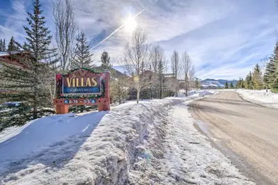 a sign in the snow next to a road at Balcony and Hot Tub Access Modern Breck Escape! in Breckenridge