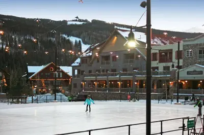 a person skating on an ice rink in front of a lodge at Expedition Station 8610 by SummitCove Lodging in Keystone
