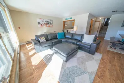 a living room with a black leather couch at Lenawee 1741 by SummitCove Lodging in Keystone