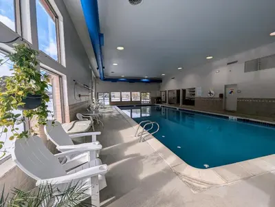 a swimming pool with two white chairs and a swimming pool at Lenawee 1741 by SummitCove Lodging in Keystone