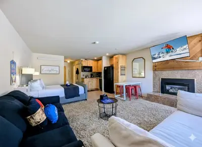a hotel room with a bed and a living room at Edgewater 1436 by SummitCove Lodging in Keystone