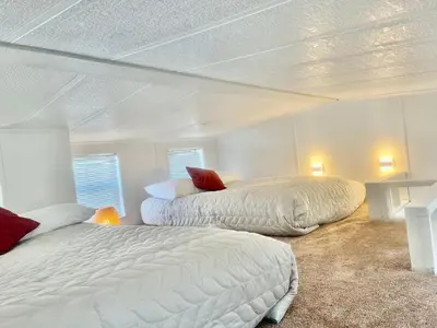 two beds in a bedroom with white walls at Sun & Snow Chalet Breckenridge, a dog lovers dream! in Breckenridge