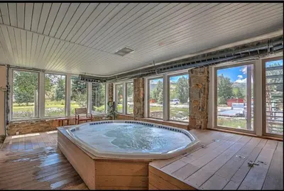 a large hot tub in a room with windows at Sun & Snow Chalet Breckenridge, a dog lovers dream! in Breckenridge