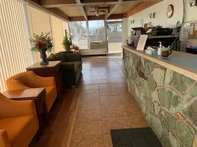 a lobby with couches and a counter in a room at Fort Collins Inn in Fort Collins