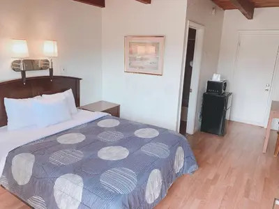 a bedroom with a bed with a blue and white comforter at Fort Collins Inn in Fort Collins