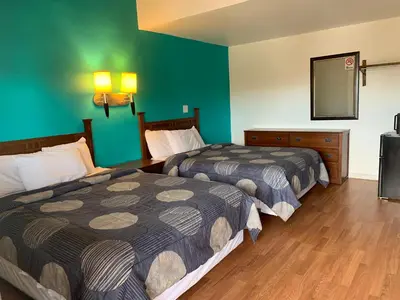 two beds in a hotel room with green walls at Fort Collins Inn in Fort Collins