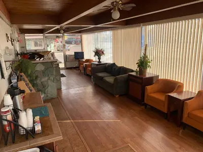 a living room with couches and chairs in a building at Fort Collins Inn in Fort Collins