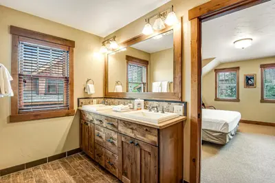a bathroom with a sink and a mirror and a bed at Winter Park Trail House in Fraser