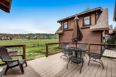 a deck with a table and chairs and a house at Winter Park Trail House in Fraser