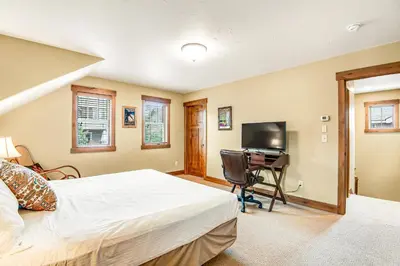 a bedroom with a bed and a desk with a television at Winter Park Trail House in Fraser