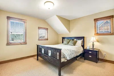 a bedroom with a bed and two windows at Winter Park Trail House in Fraser