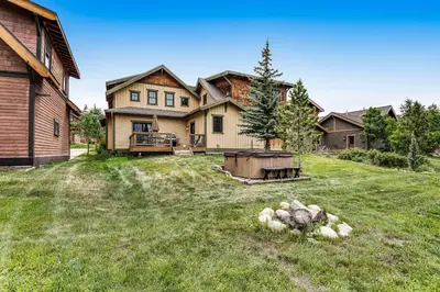 a large house with a yard with a fire pit at Winter Park Trail House in Fraser