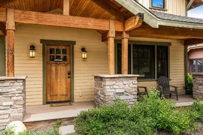 a front porch of a house with a wooden door at Winter Park Trail House in Fraser
