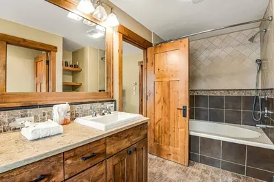 a bathroom with a sink and a tub and a shower at Winter Park Trail House in Fraser