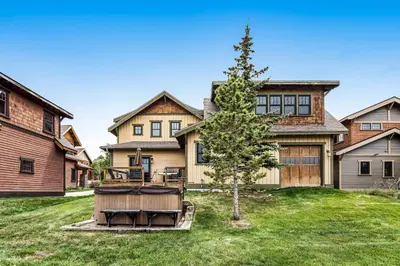 a large house with a tree in the yard at Winter Park Trail House in Fraser