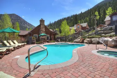 a swimming pool with a brick patio and a house at Settlers Creek in Keystone