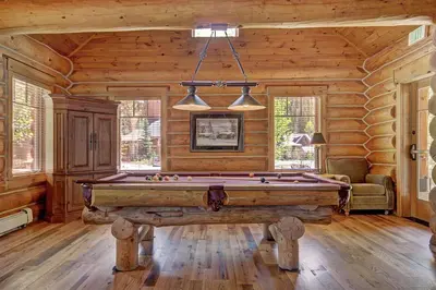 a room with a pool table in a log cabin at Settlers Creek in Keystone