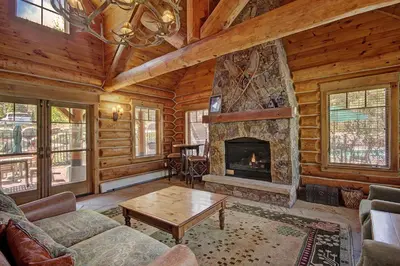 a living room with a fireplace in a log cabin at Settlers Creek in Keystone