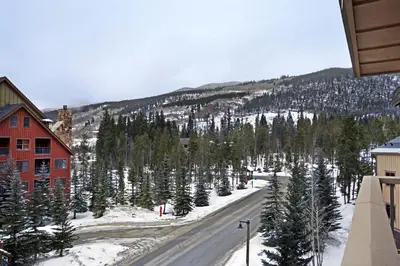 a snowy road with trees and a mountain at Red Hawk Lodge Condo in Keystone