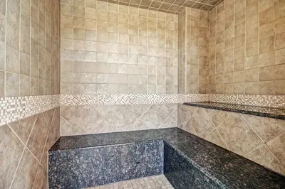 a bathroom with a large shower with brown tiles at Red Hawk Lodge Condo in Keystone