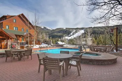 a patio with tables and chairs next to a pool at Dakota Lodge in Keystone