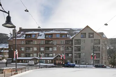 a large building in front of a snow covered mountain at Dakota Lodge in Keystone