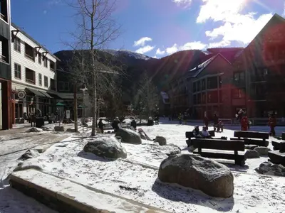 a snow covered town with people sitting on benches at Dakota Lodge in Keystone