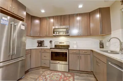 a kitchen with stainless steel appliances and wooden cabinets at 201 Point Drive condo in Frisco
