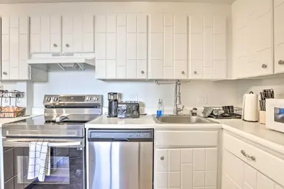 a kitchen with white cabinets and stainless steel appliances at Steps to Dillon Reservoir Mtn-View Condo in Dillon