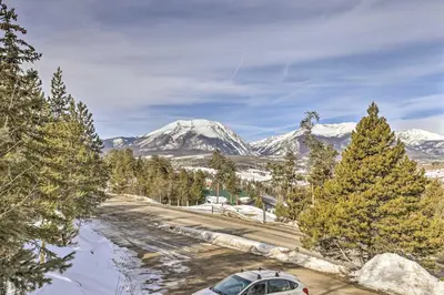 a snow covered mountain with a car parked on a road at Steps to Dillon Reservoir Mtn-View Condo in Dillon