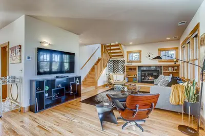 a living room with a couch and a tv at Brilliant Posh Home - Backs to Poudre River Trail! in Fort Collins
