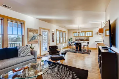 a living room with a couch and a table at Brilliant Posh Home - Backs to Poudre River Trail! in Fort Collins