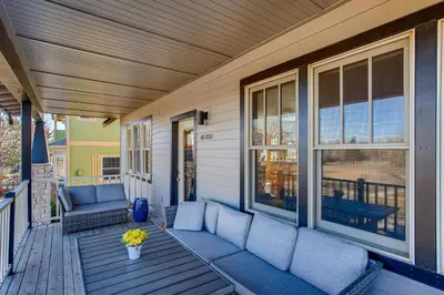 a porch with a couch and a table on a house at Brilliant Posh Home - Backs to Poudre River Trail! in Fort Collins