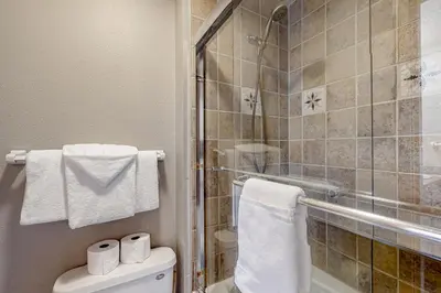 a bathroom with a shower and a toilet and towels at Montezuma Magic in Keystone