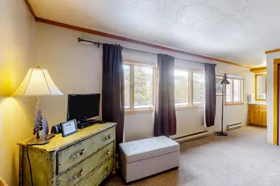 a living room with a dresser with a television on it at Montezuma Magic in Keystone
